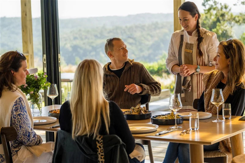 Group of people dining at a table with a scenic view in the background