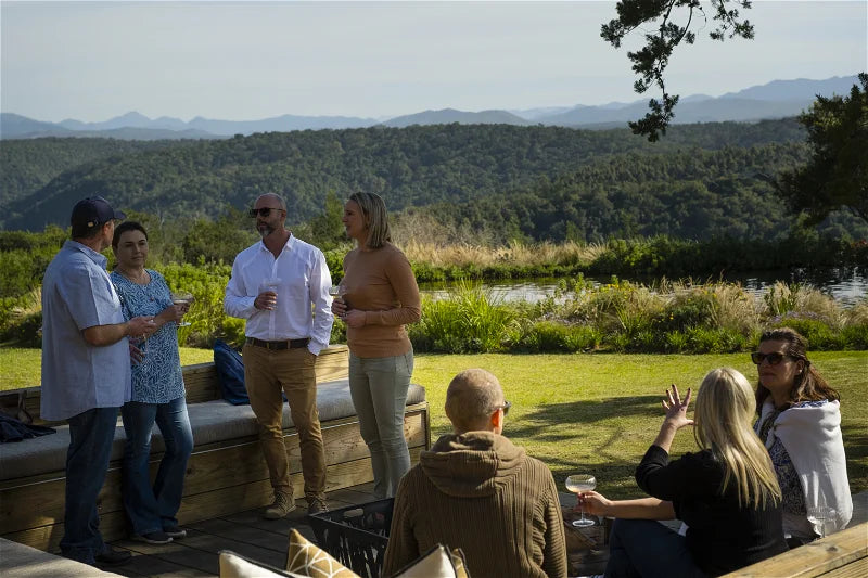 Group of people socializing outdoors with a scenic background